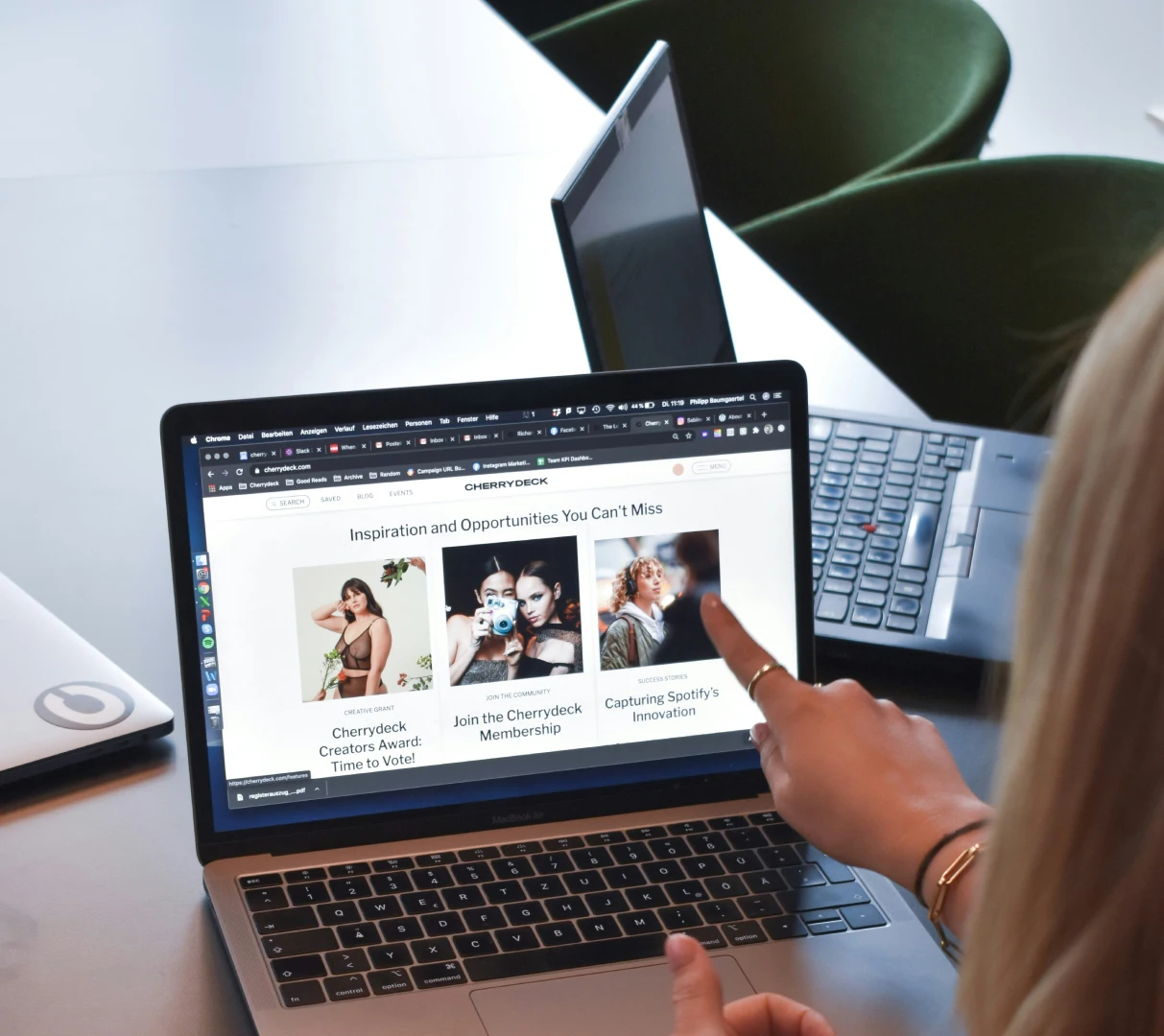 Close-up of a person scrolling through a digital agency's website on a laptop, browsing project highlights and community features.