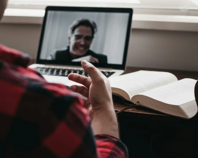 People in a meeting working together in front of a laptop in a collaborative workspace.